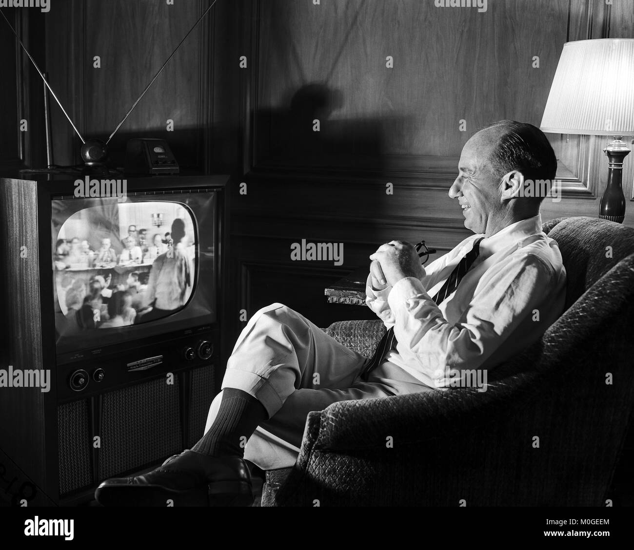 Governor Adlai Stevenson watches the Democratic convention on TV at the home of William McCormick Blair Jr. in Chicago. July 22, 1952. Stock Photo