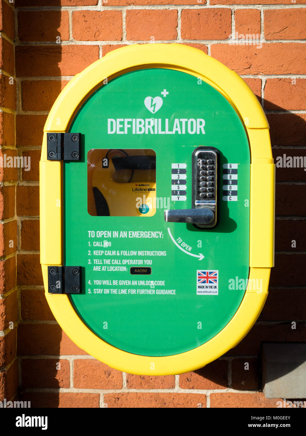 Public Defibrillator on a wall. The user dials 999 to get the open code before using the Defibtech Lifeline auto defibrillator. Stock Photo
