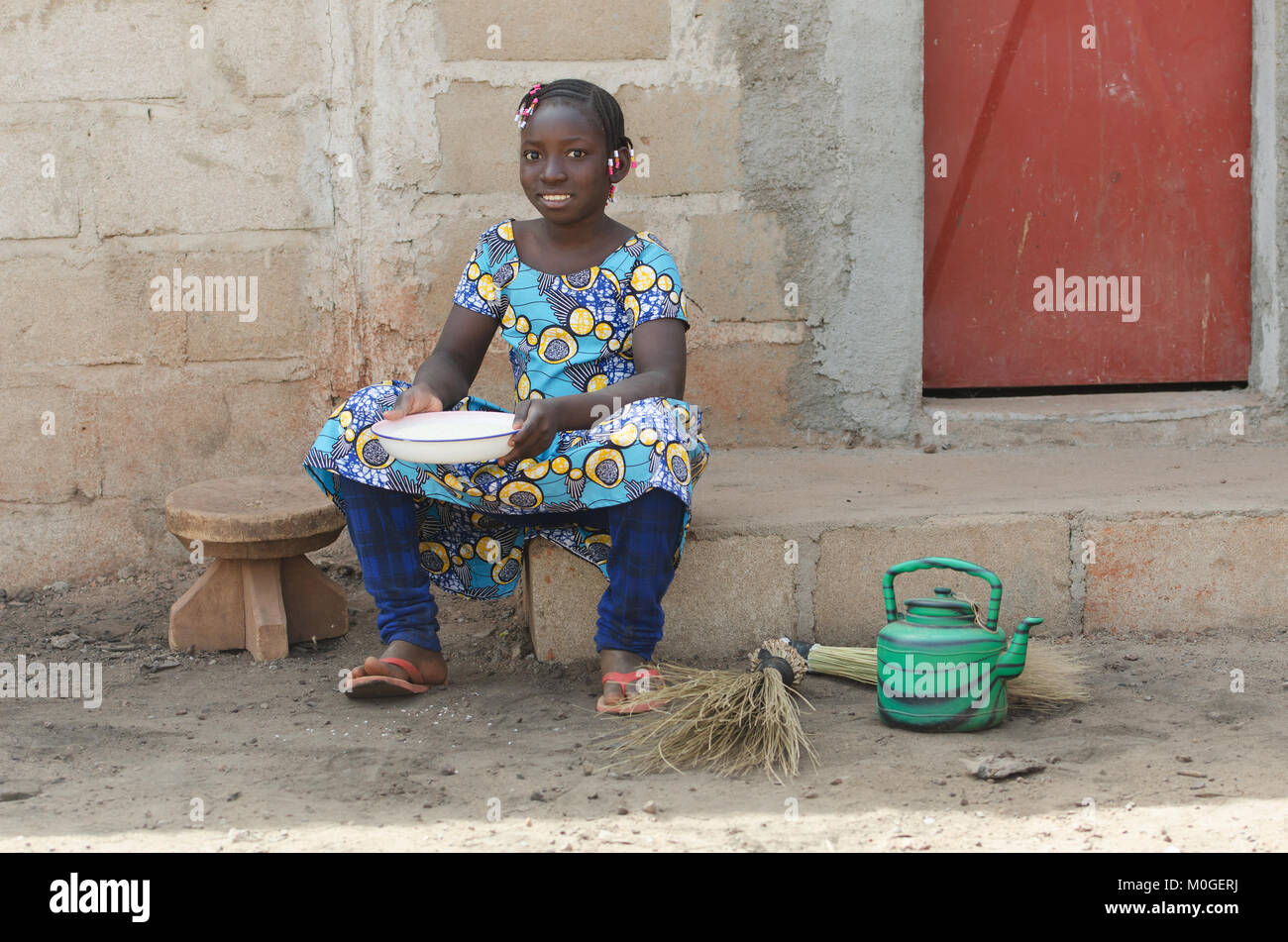 Little African Girl Cooking Rice Outdoors Smiling at Camera Stock Photo