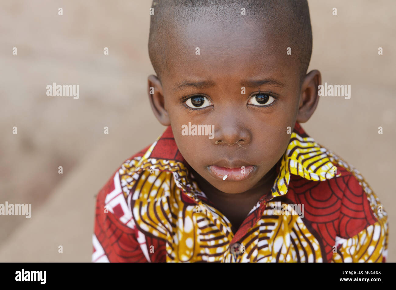 Hunger Africa Symbol - Little African Boy with Rice on Mouth Stock Photo