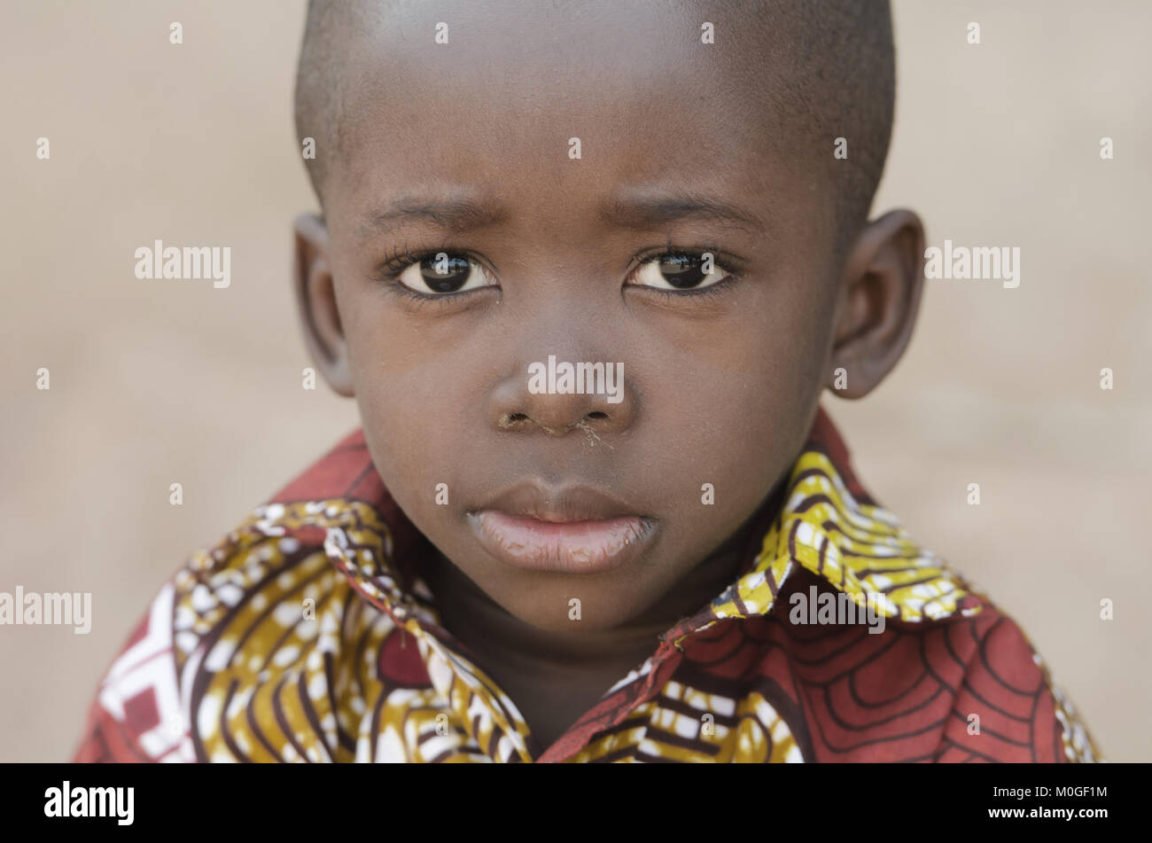 Little African Black Boy Looking Sad at Camera Stock Photo