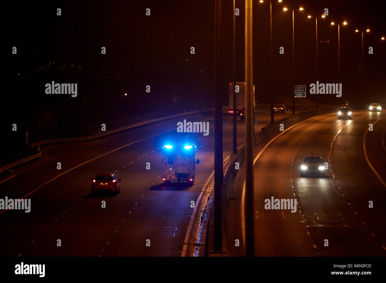 ambulance speeding along motorway with blue lights flashing in northern ireland uk Stock Photo