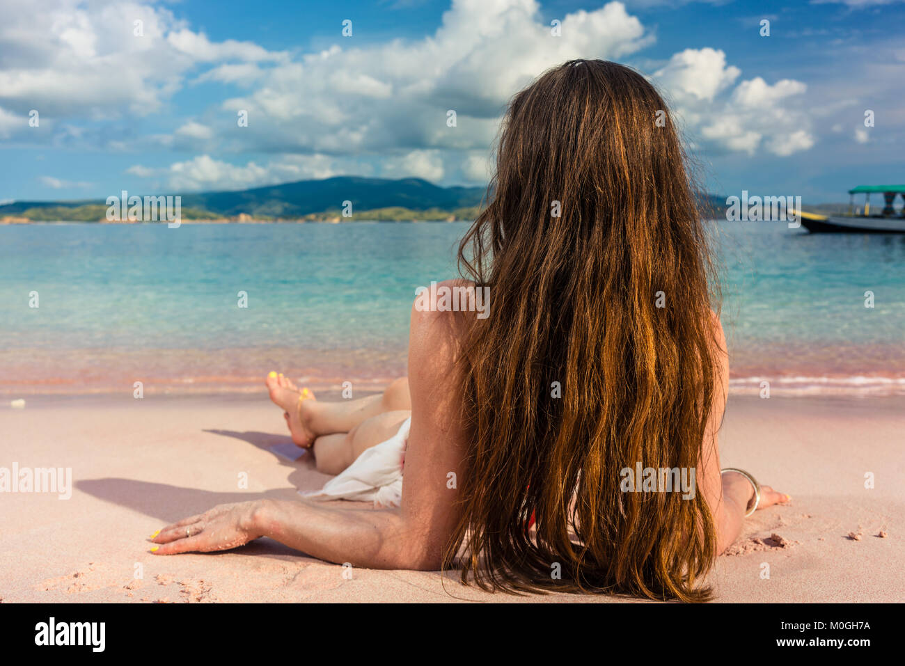 Young woman with long brown hair daydreaming while lying down on Stock Photo