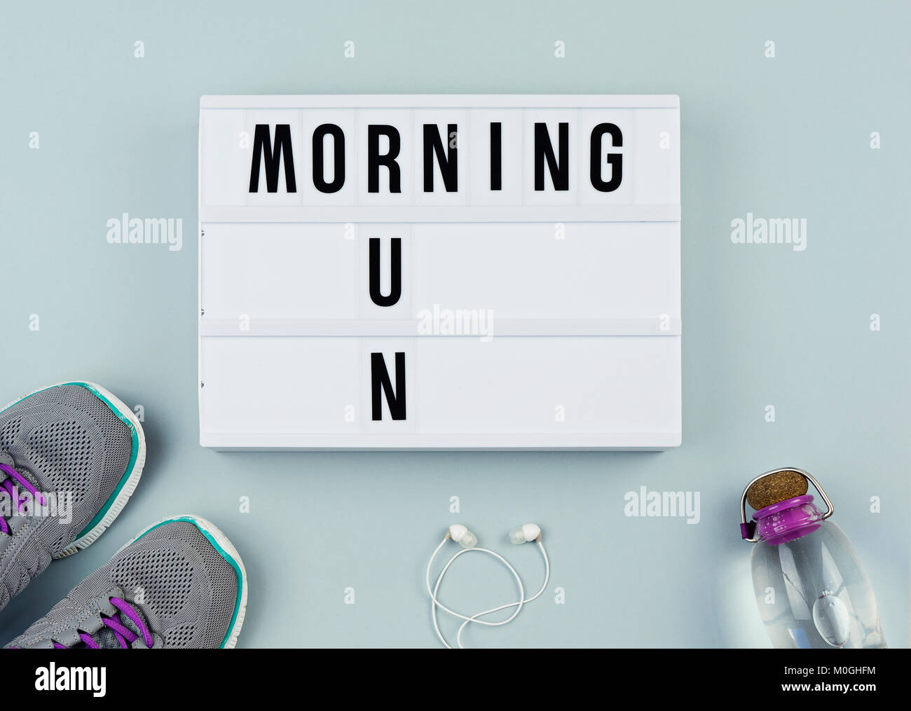 Set for sport activity: running shoes, headphones, bottle of water and motivation on the gray background top view flat lay concept Stock Photo