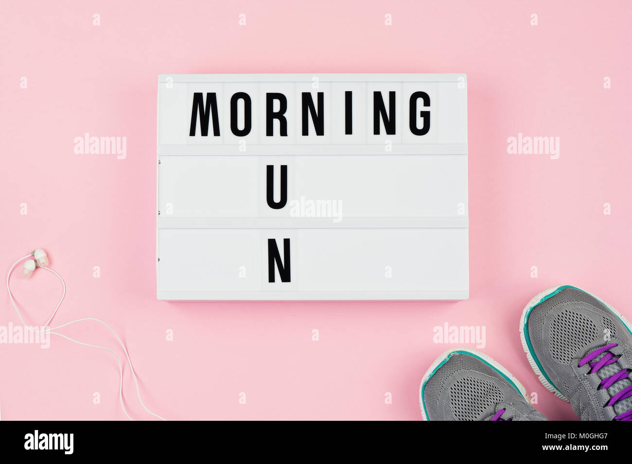 Morning run text on light box, headphones and sport shoes on the pink Stock Photo