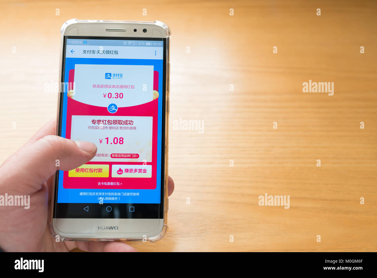 Zhongshan,China-January 13, 2018:Chinese man getting an Alipay red pocket on the mobile.Alibaba sends out lots of free red pockets as gift to users in 2017 & 2018. Stock Photo