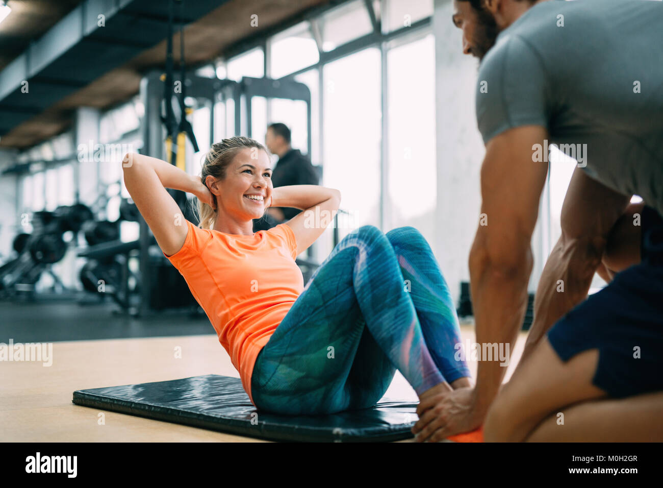 Personal trainer assisting woman lose weight Stock Photo Alamy