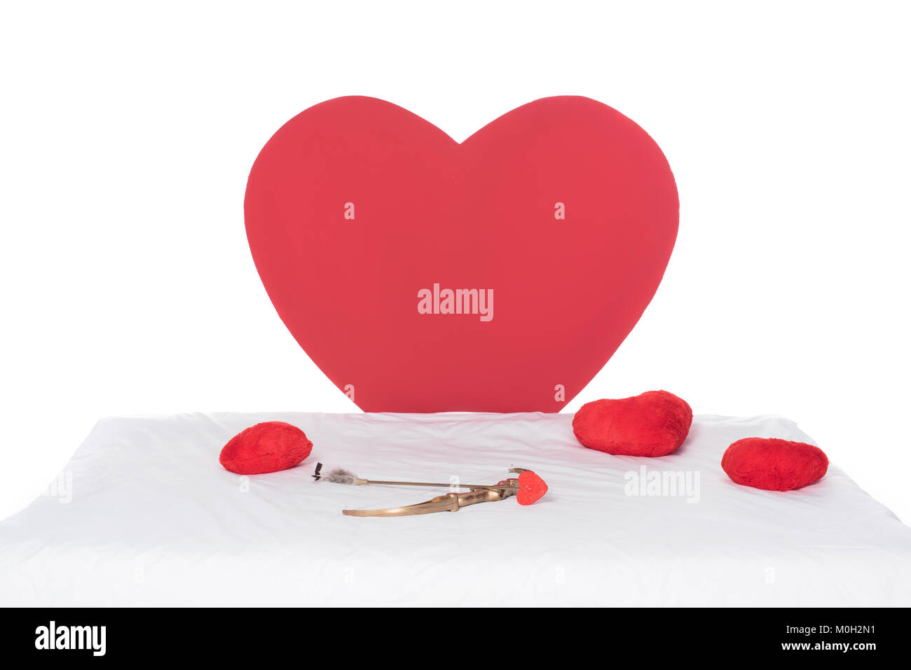 heart pillows, wings, bow and arrow on white bed Stock Photo Alamy
