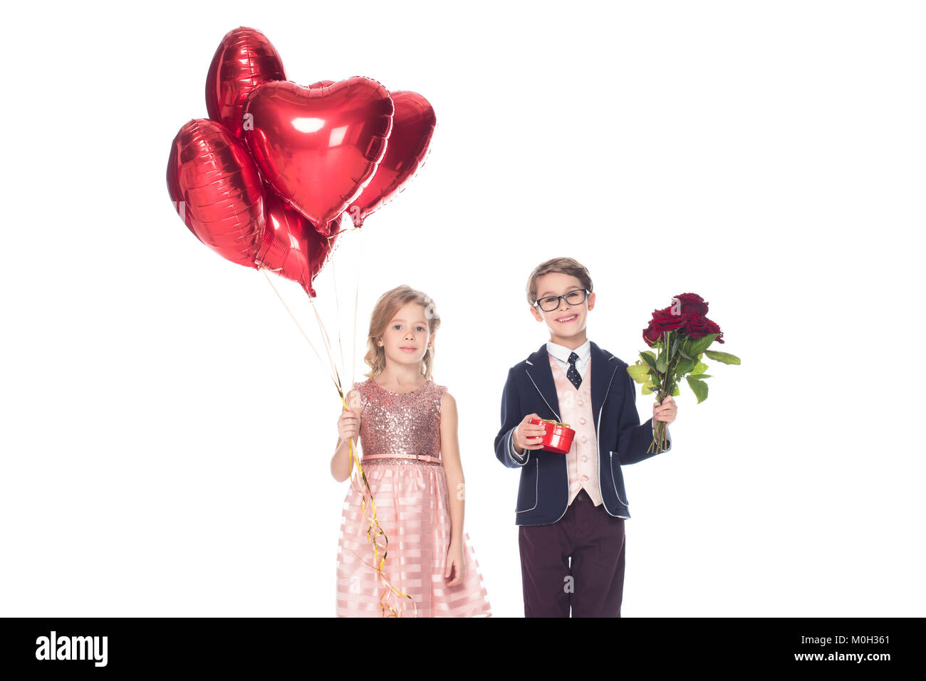adorable happy little couple with heart shaped balloons, gift box and ...