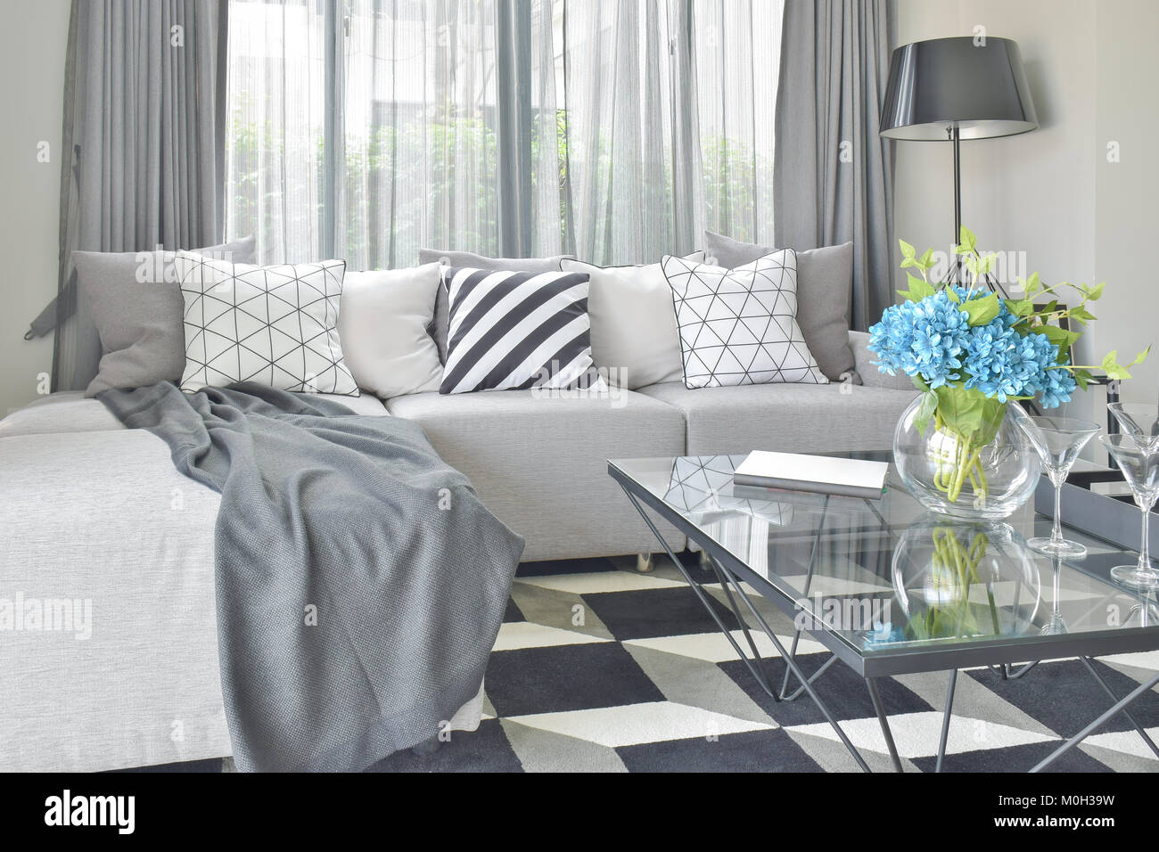 Light gray L shape sofa set with varies pattern and color pillows in modern  living room Stock Photo - Alamy