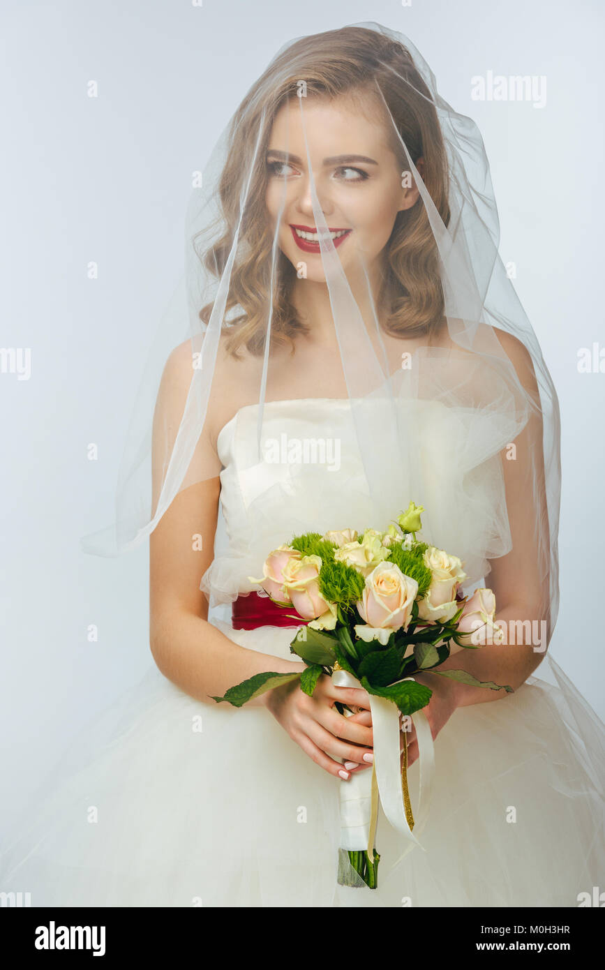 portrait of pretty bride in wedding dress and veil with wedding bouquet ...