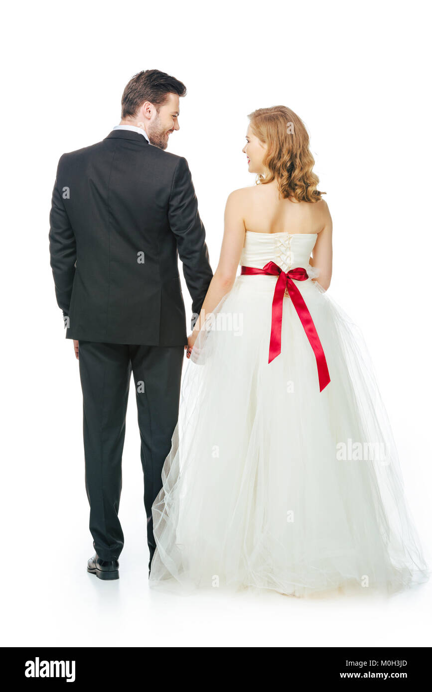 back view of bride and groom holding hands isolated on white Stock ...
