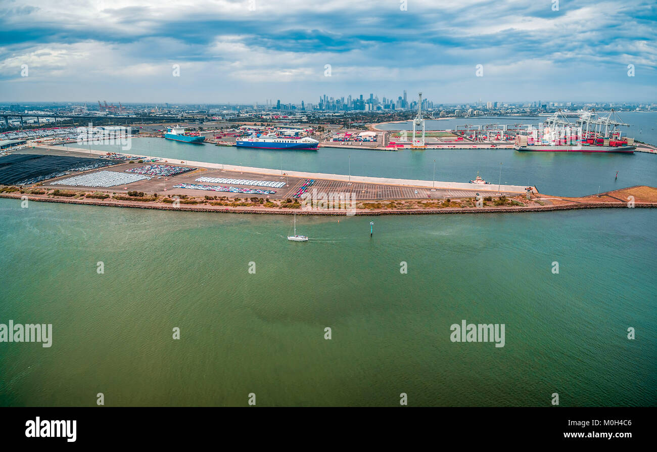 Aerial view of Port Melbourne with moored cargo vessels and Melbourne CBD skyline on the horizon Stock Photo