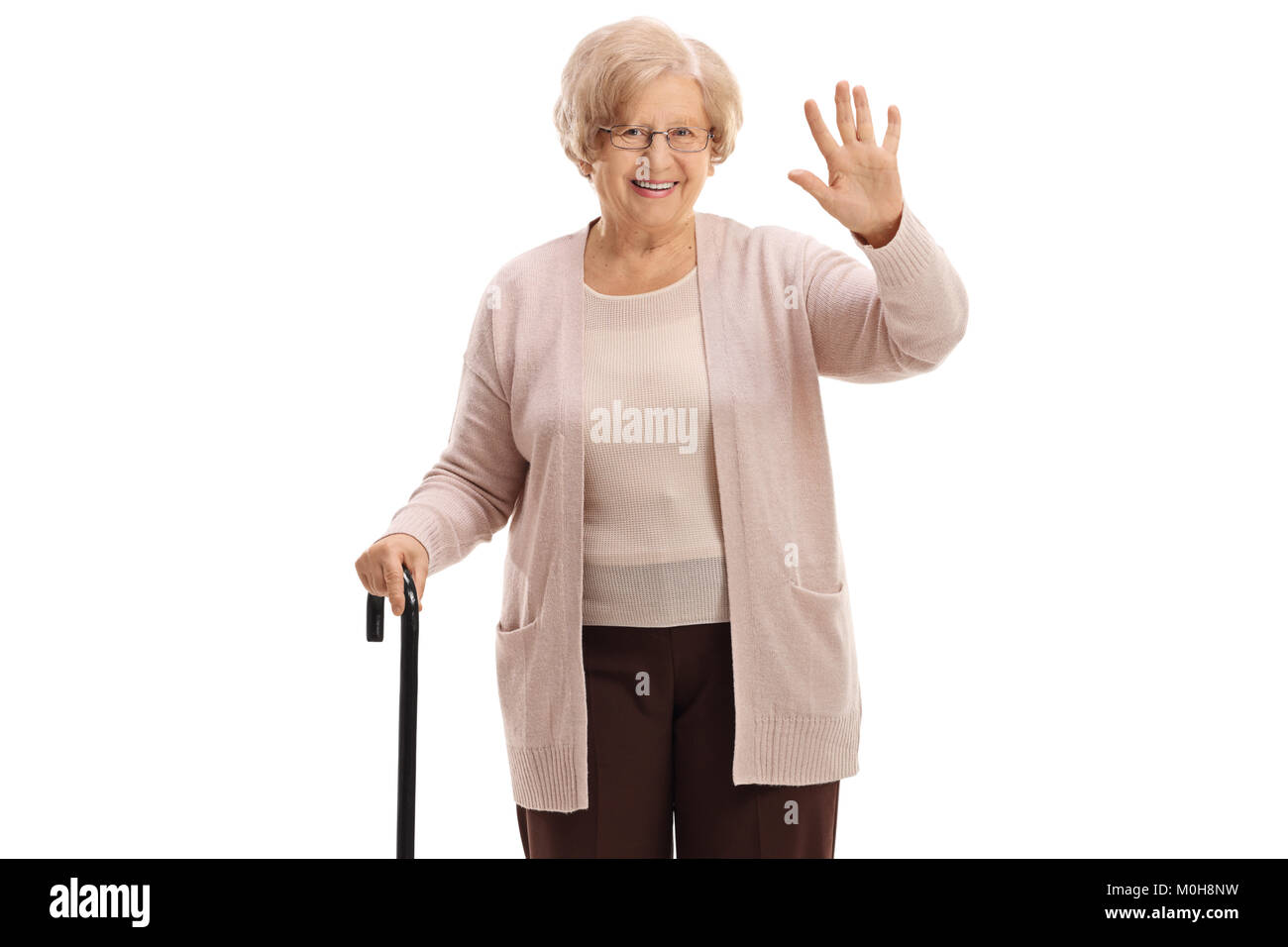 Elderly woman with a cane waving at the camera isolated on white background Stock Photo