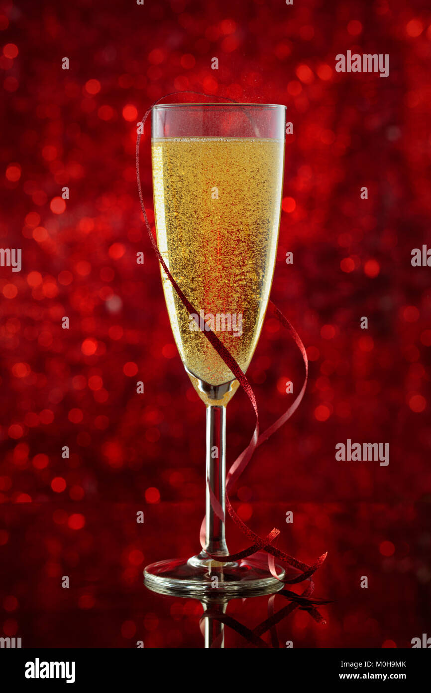Glass of champagne and red decoration of lights. Stock Photo