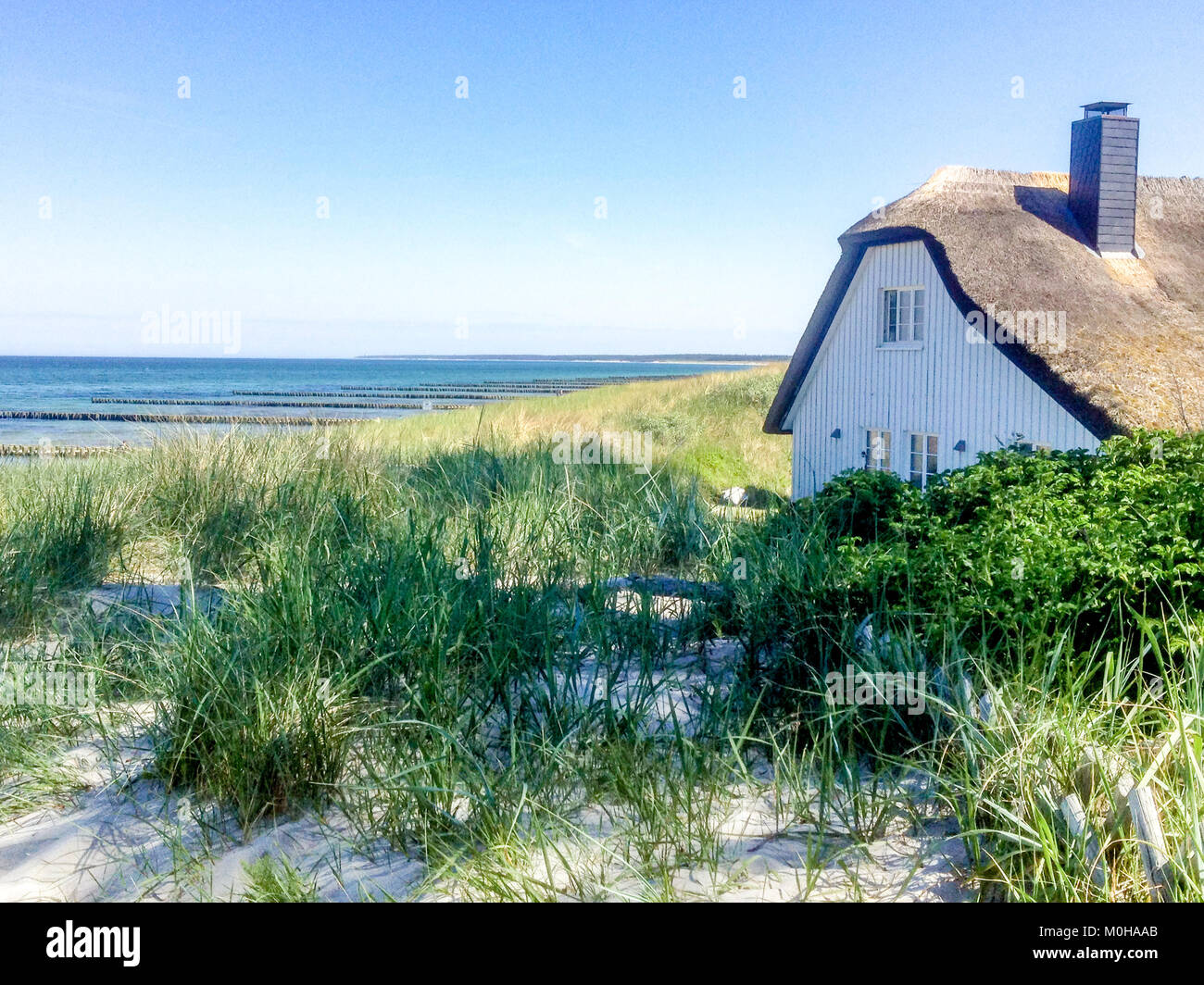 beautiful house with Roof ree or thatch on the beach between the dunes while morning Stock Photo