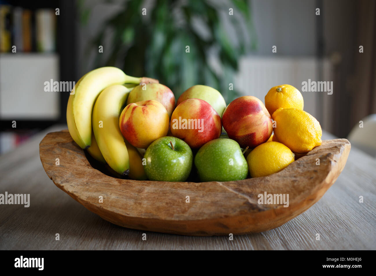 Wooden fruit basket on table in living room Stock Photo Alamy