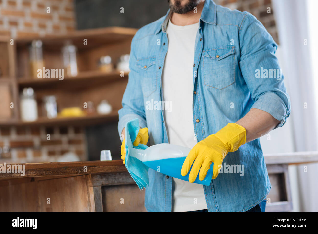 Young male cleaner pouring cleanser Stock Photo