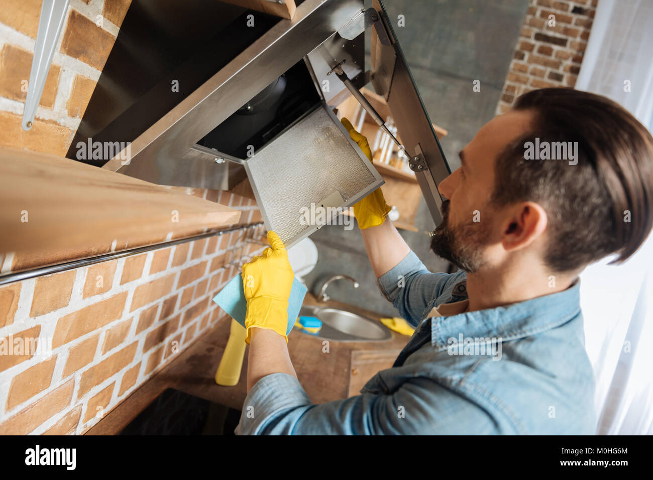 Bearded male cleaner cleaning cooker hood Stock Photo Alamy