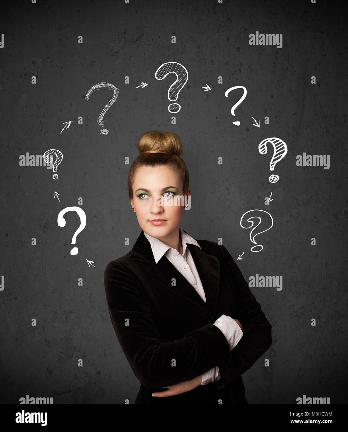 Thoughtful young woman with drawn question marks circulating around her ...