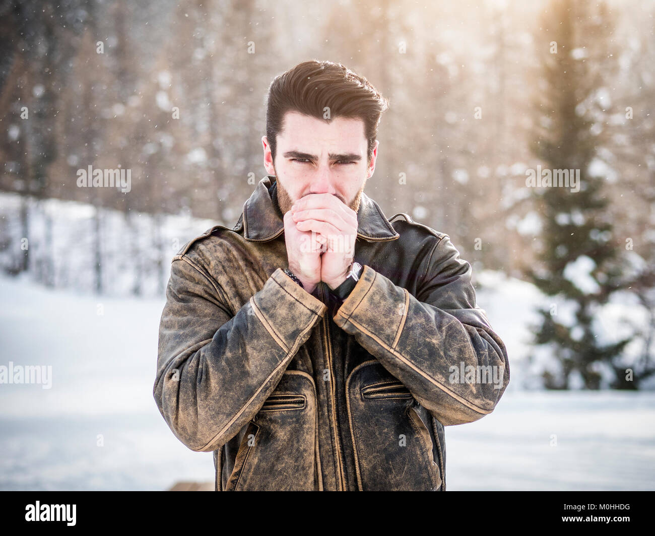 Portrait of young man in hoodie posing outdoor in winter setting with snow  all around, looking at camera Stock Photo - Alamy