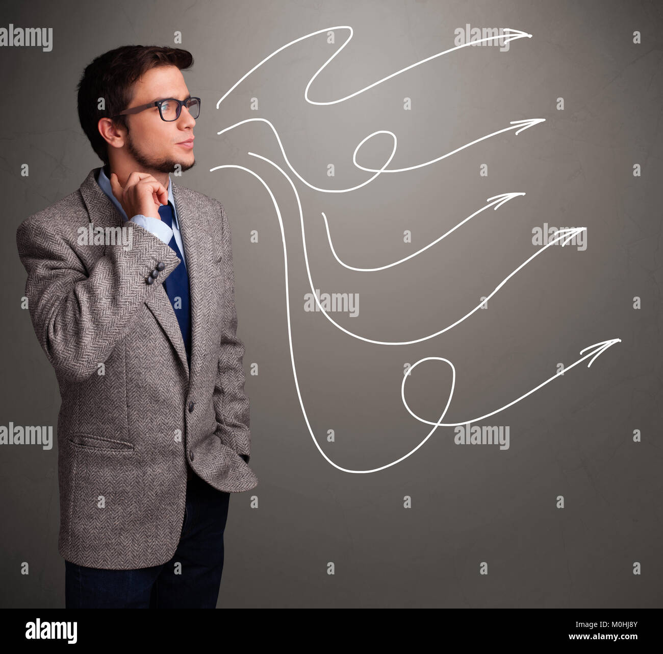 Attractive young man looking at multiple curly arrows Stock Photo