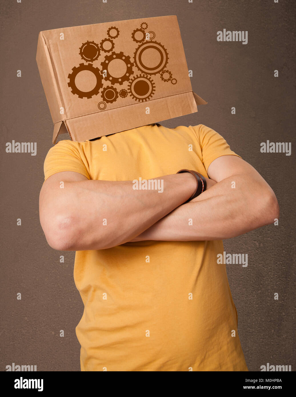 Young man standing and gesturing with a cardboard box on his head with ...
