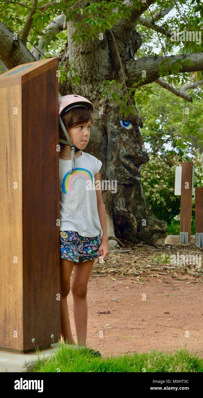Young girl listening to Billy the bombax tree information, Anderson Park Botanic Gardens, Townsville, Queensland, Australia Stock Photo