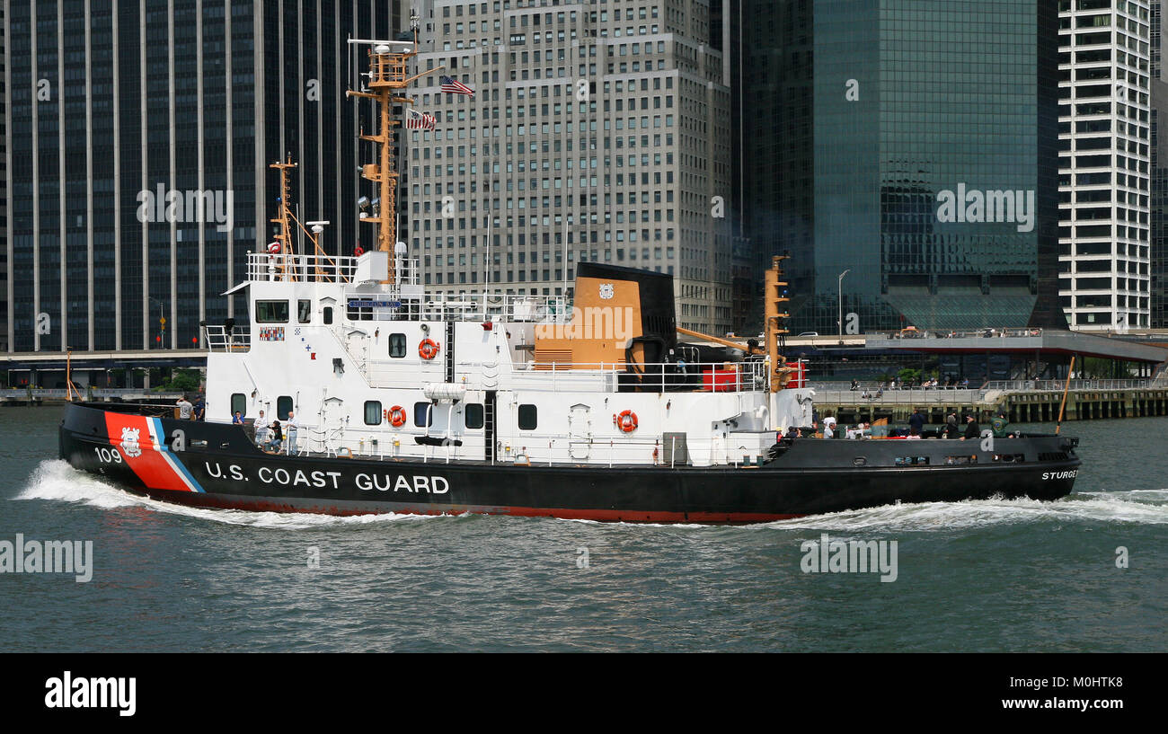 USCGC Sturgeon Bay (WTGB 109) sailing in front of The Continental Center and 120 Wall Street Building skyscrapers near piers 15 & 17, East River, Lowe Stock Photo