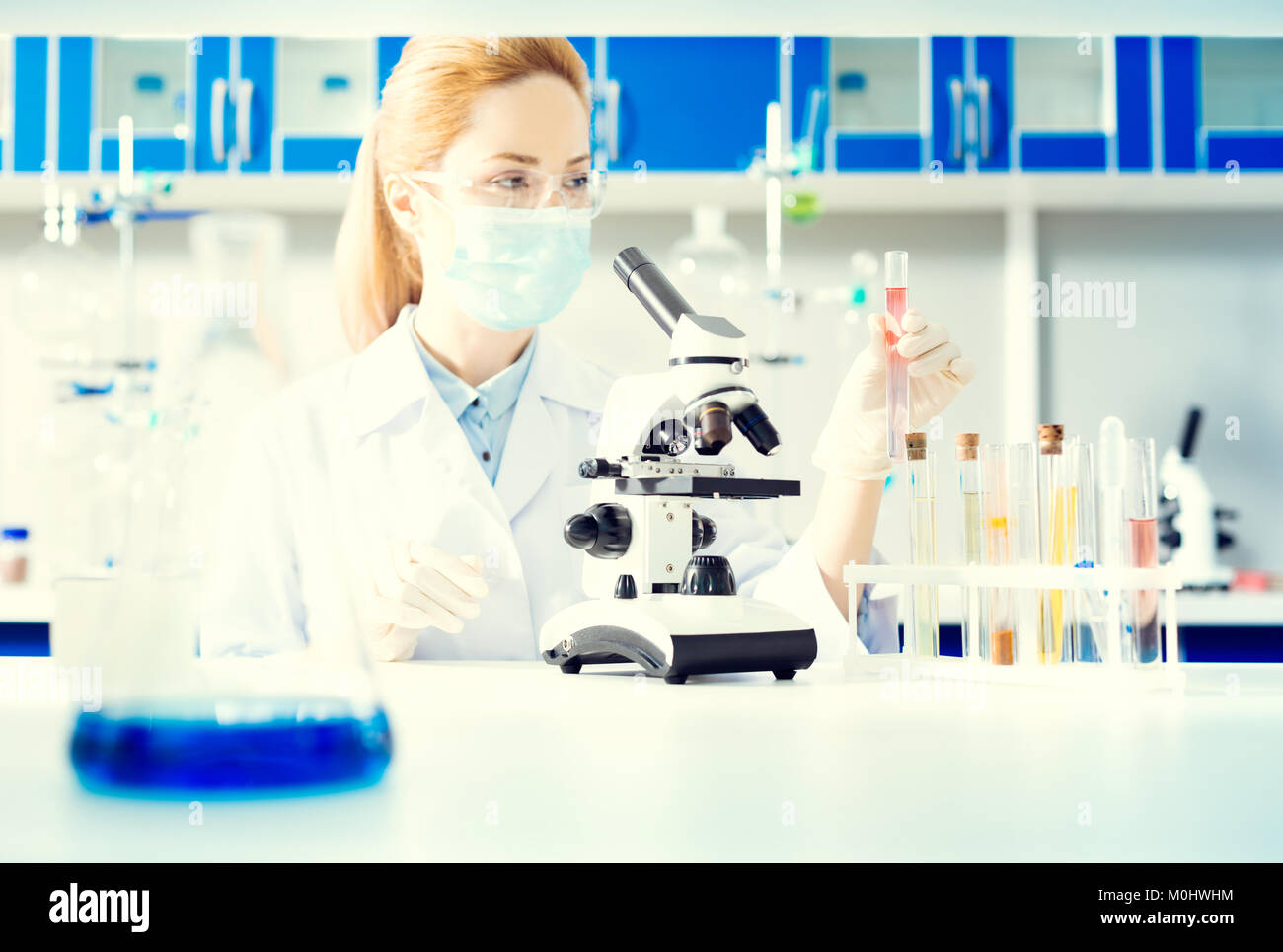 Female lab worker conducting chemical experiment Stock Photo