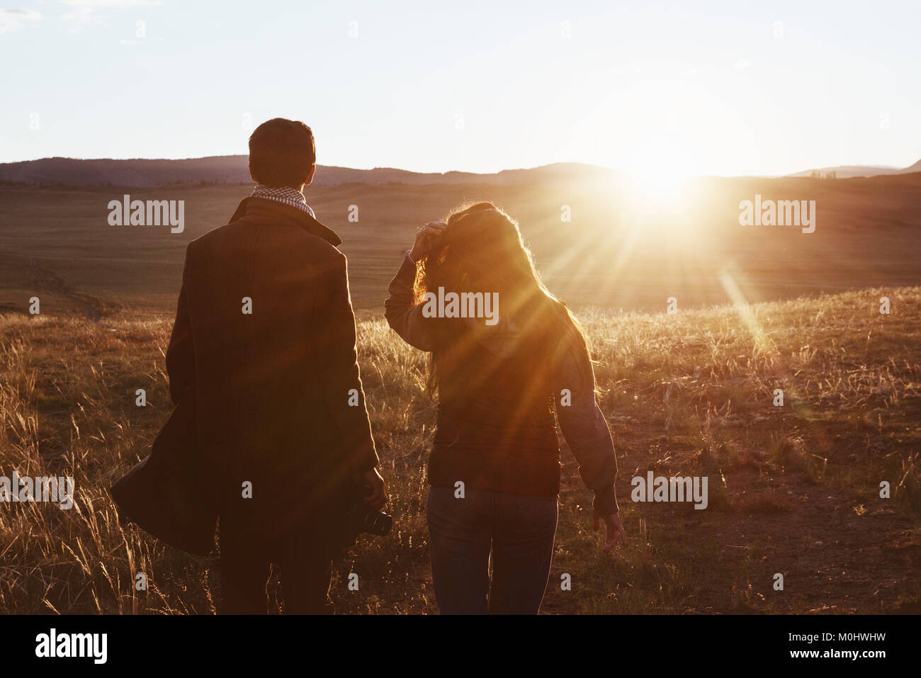 Couple travellers against sunset mountain Stock Photo