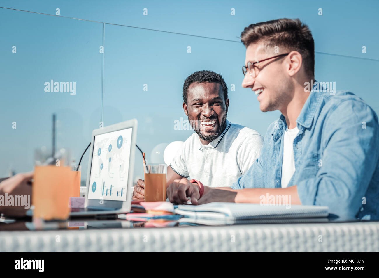 Extremely happy guys laughing during lunch break Stock Photo