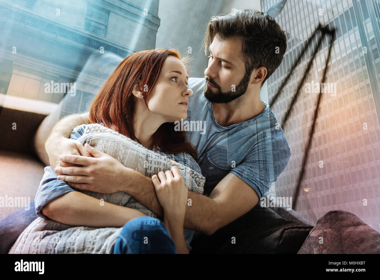Loving couple looking attentively at each other and hugging Stock Photo