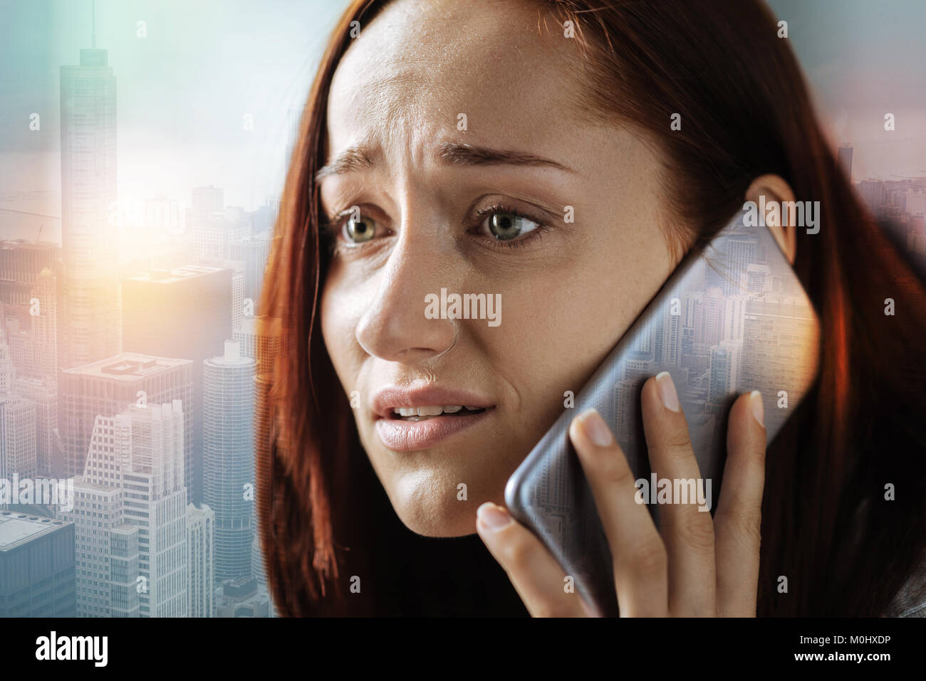 Worried woman looking scared while talking on the phone Stock Photo Alamy