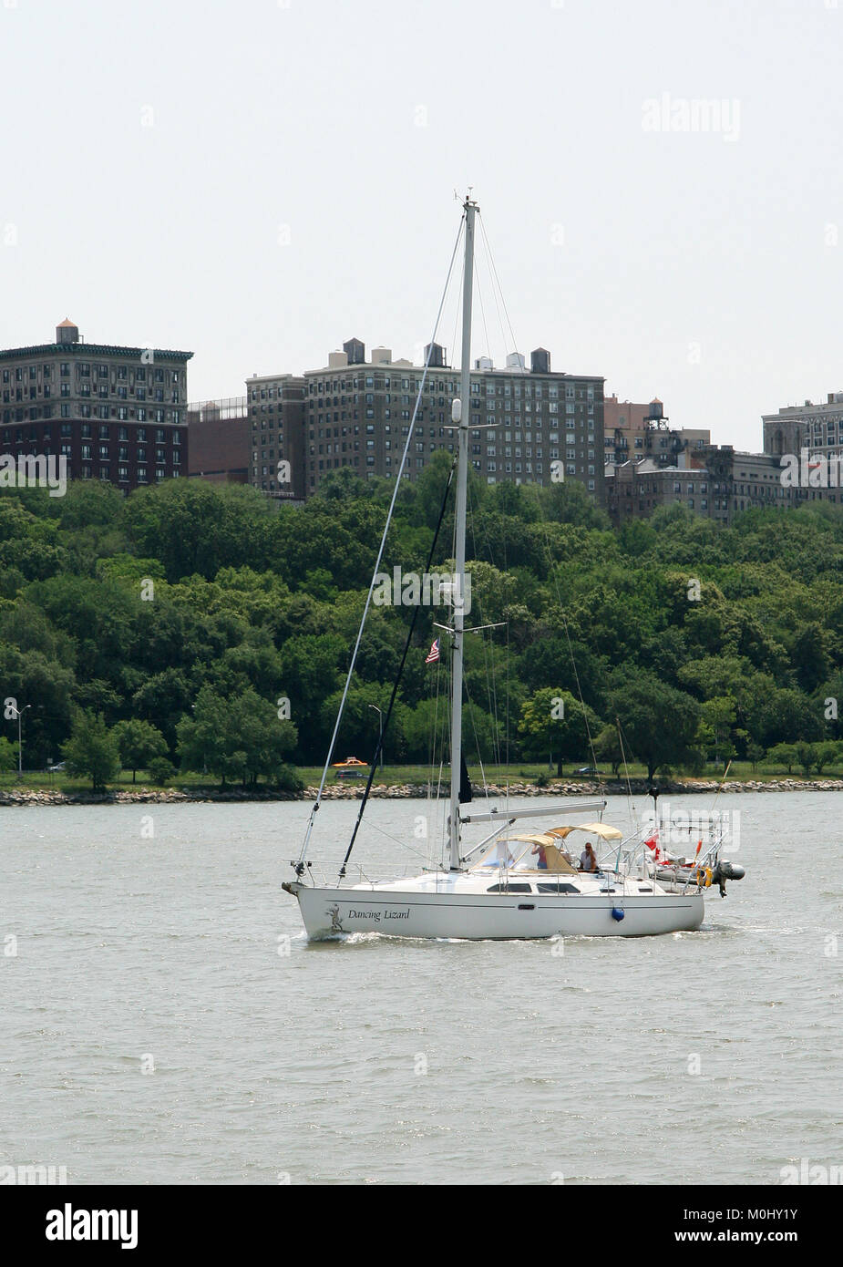 Two people on a small yacht around Upper West Side Manhattan on the Hudson River, New York City, New York State, USA. Stock Photo