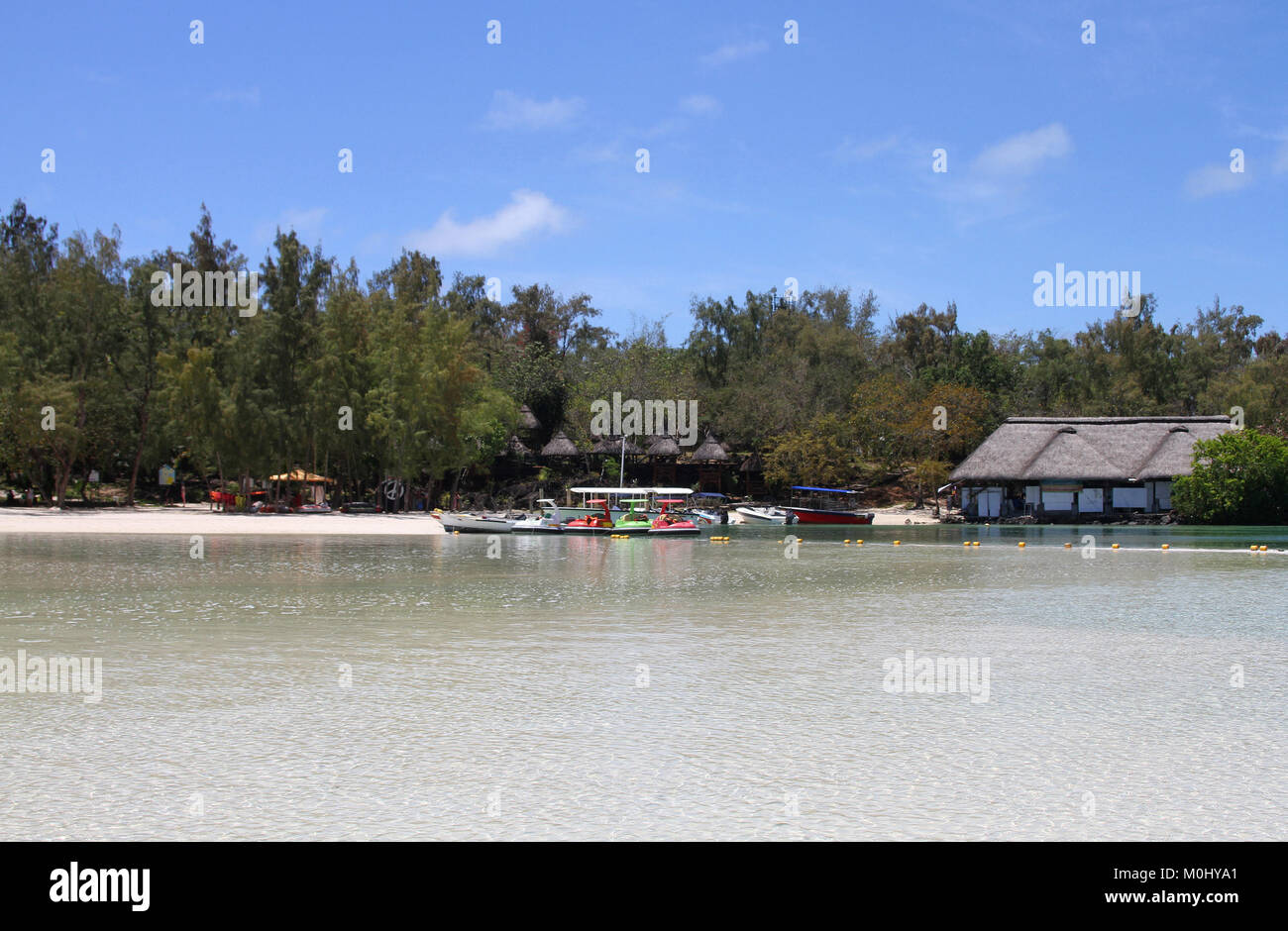 Tied up motorized bumper boats and huts on The Ile Aux Cerfs, a privately owned island near the east coast of The Republic of Mauritius in the Flacq D Stock Photo