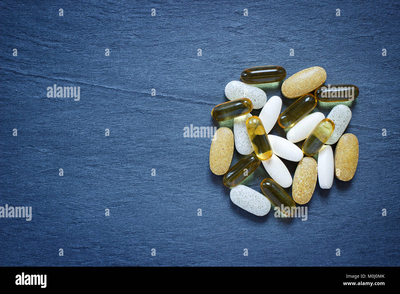 Pile of healthy supplements on stone background Stock Photo - Alamy