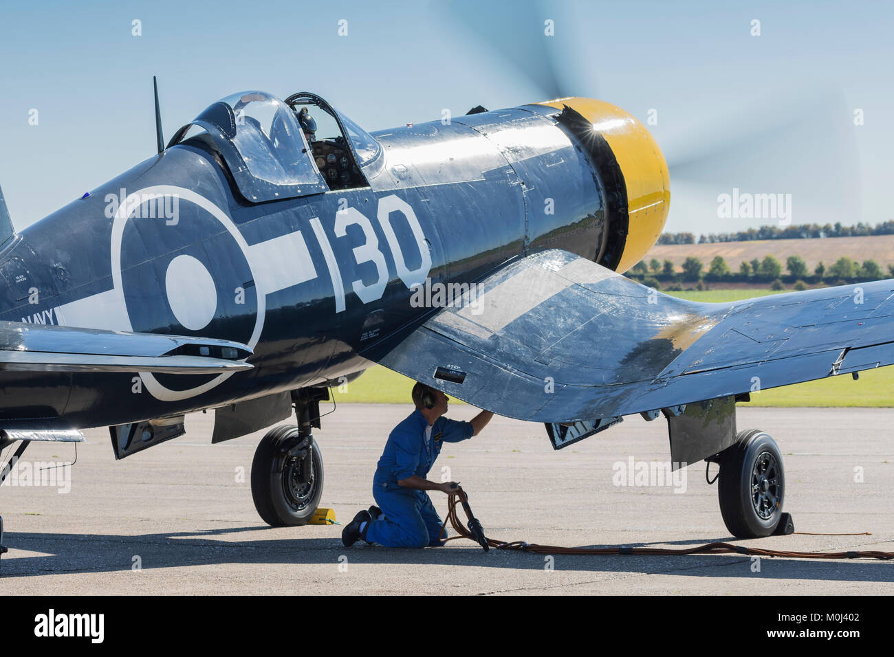Goodyear Corsair FG-1D aircraft on the apron with ground crew technician prior to flight on September 22nd 2017 at Duxford, Cambridgeshire, UK Stock Photo