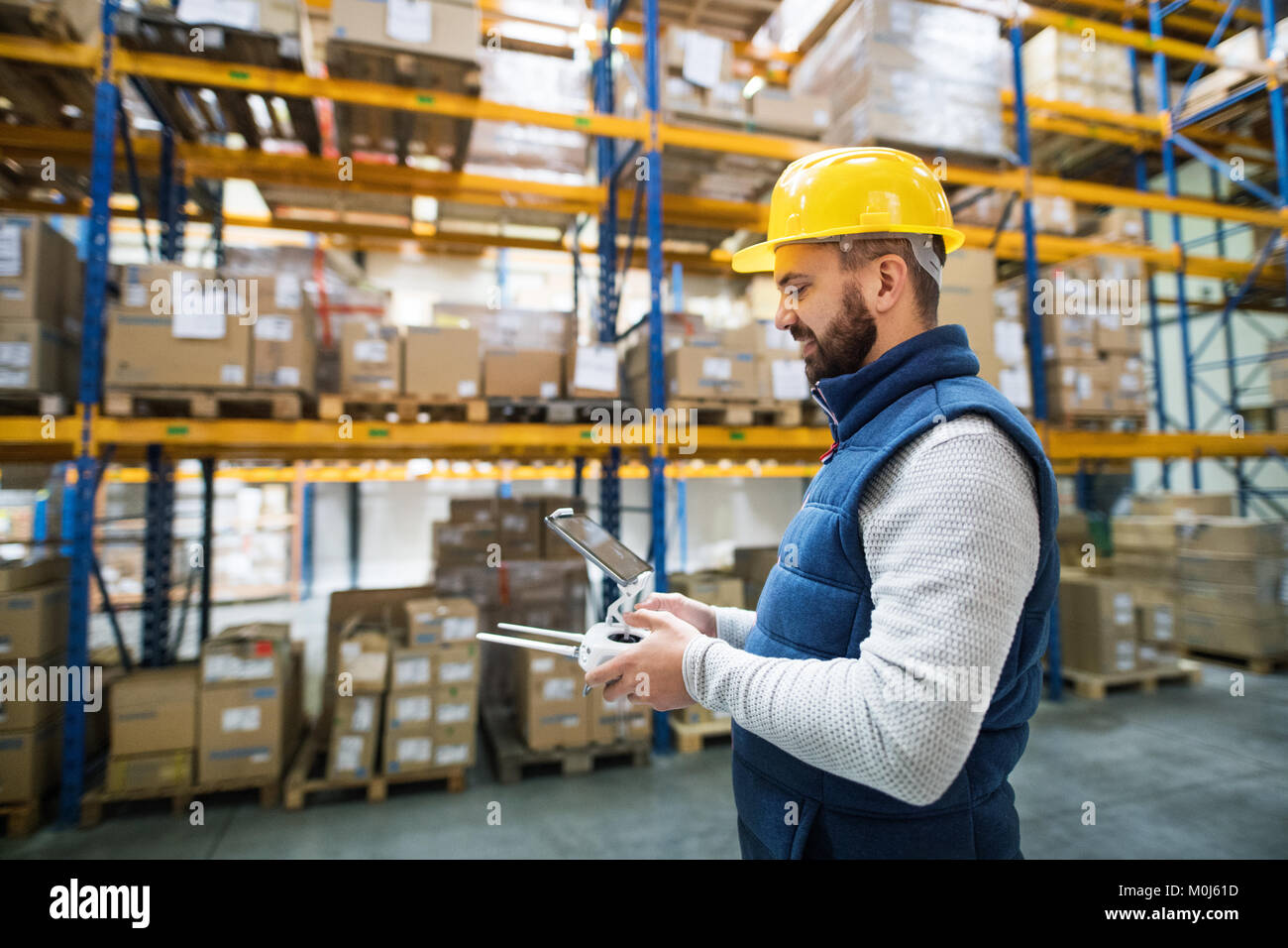 Man with tablet and drone controller in a warehouse. Stock Photo