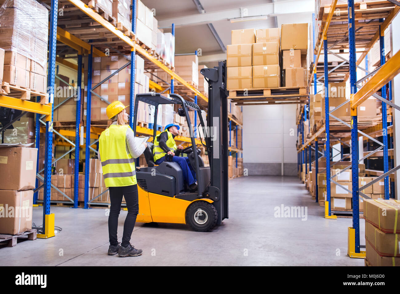 Young warehouse workers working together Stock Photo - Alamy