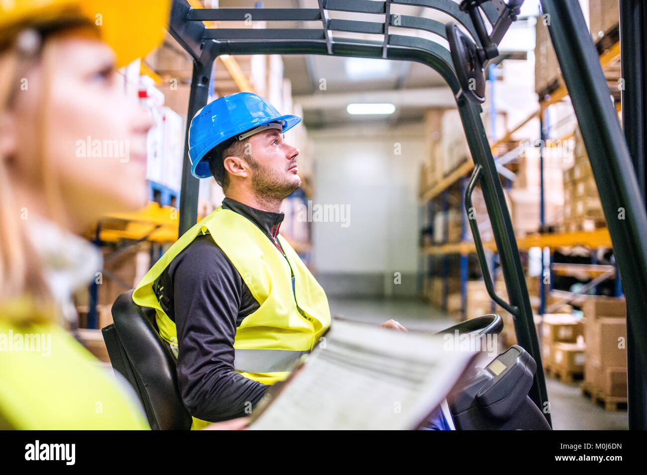 Young warehouse workers working together Stock Photo - Alamy