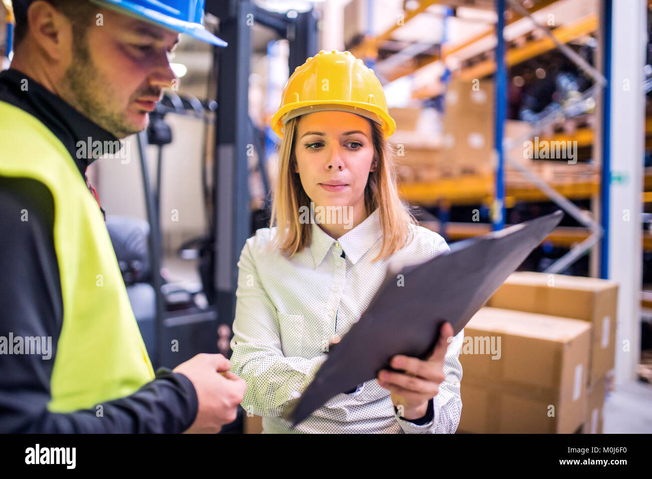 Young warehouse workers working together Stock Photo - Alamy