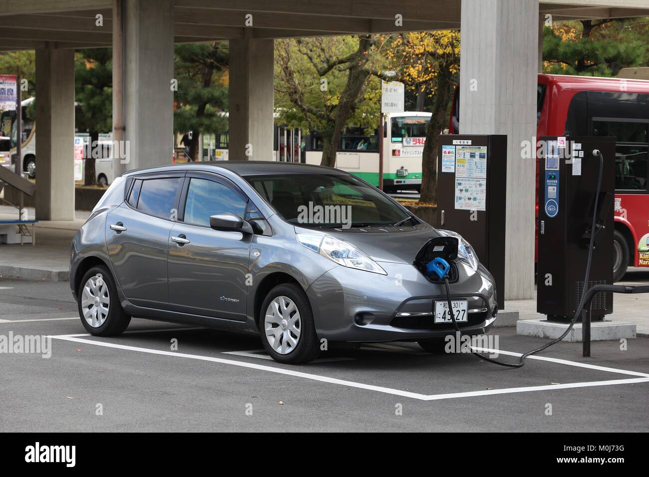 NARA, JAPAN - NOVEMBER 23, 2016: Nissan Leaf electric car charging at a station in Nara, Japan. Zero-emissions vehicles have improved vastly in recent Stock Photo