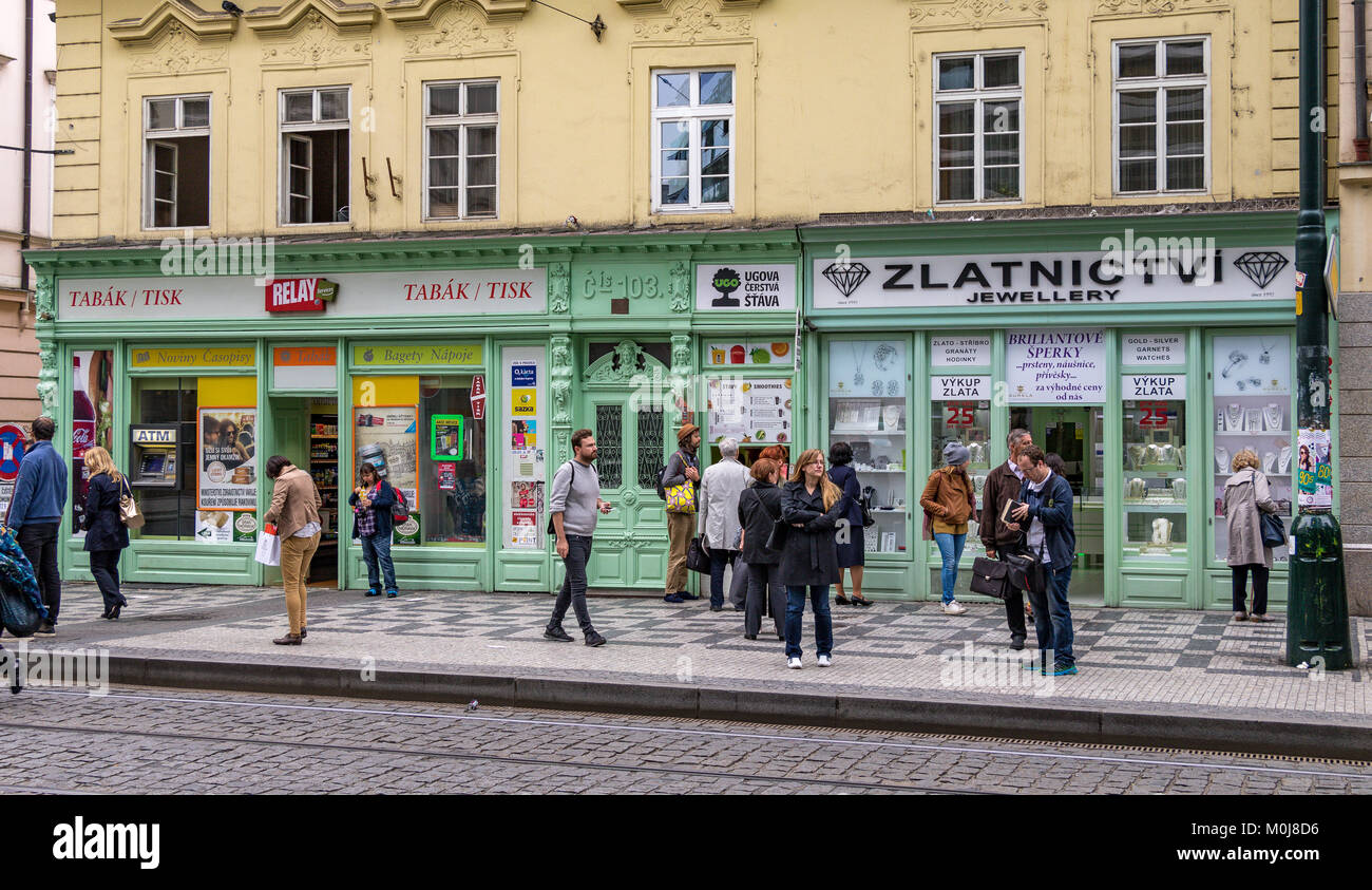 People waiting for a tram at at a tram stop outside Zlatnictvi Jewellery shop along  Spálená in Prague , Czech Republic Stock Photo