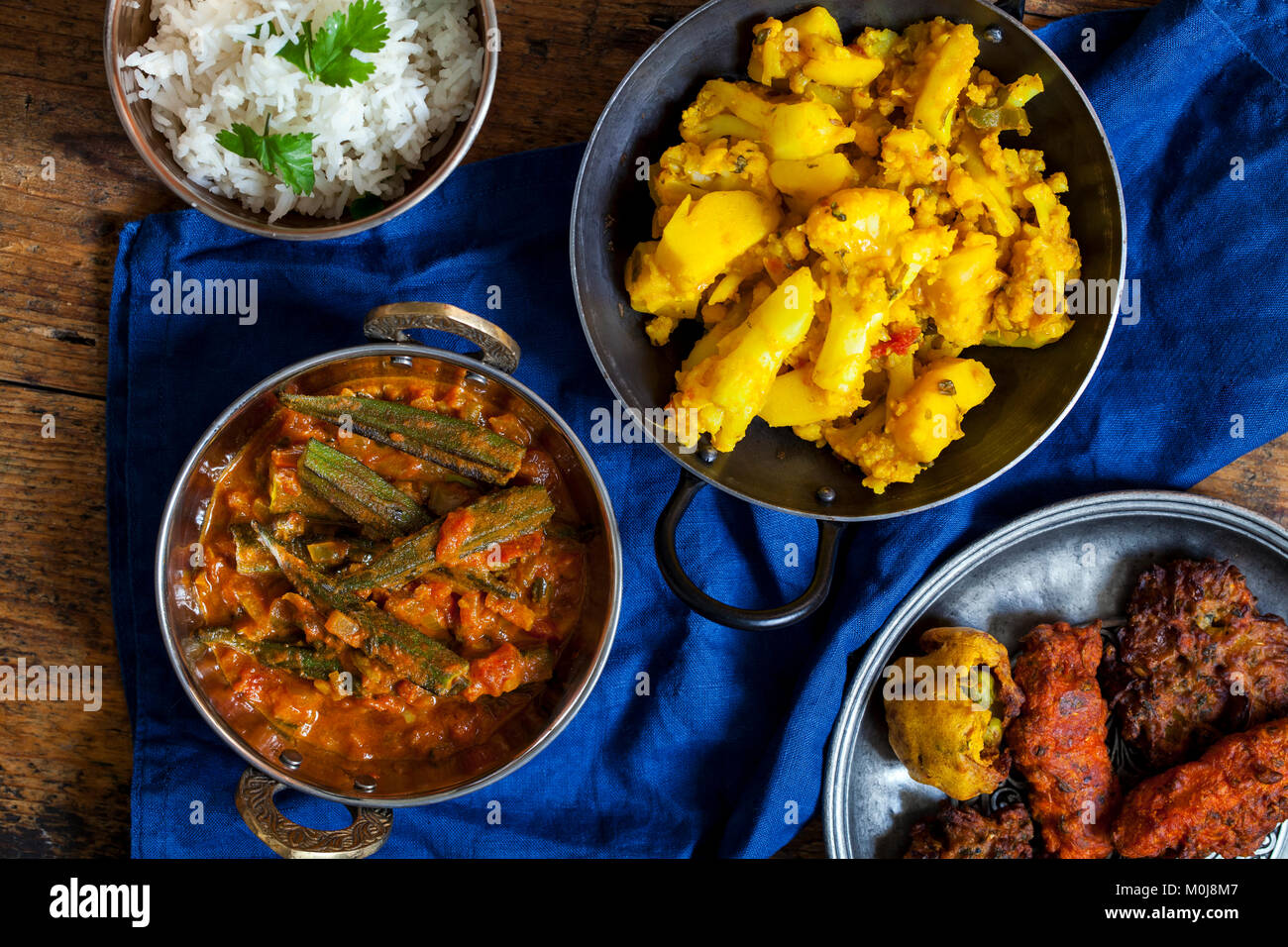 Indian meal with aloo gobi, okra curry, rice and pakoras Stock Photo