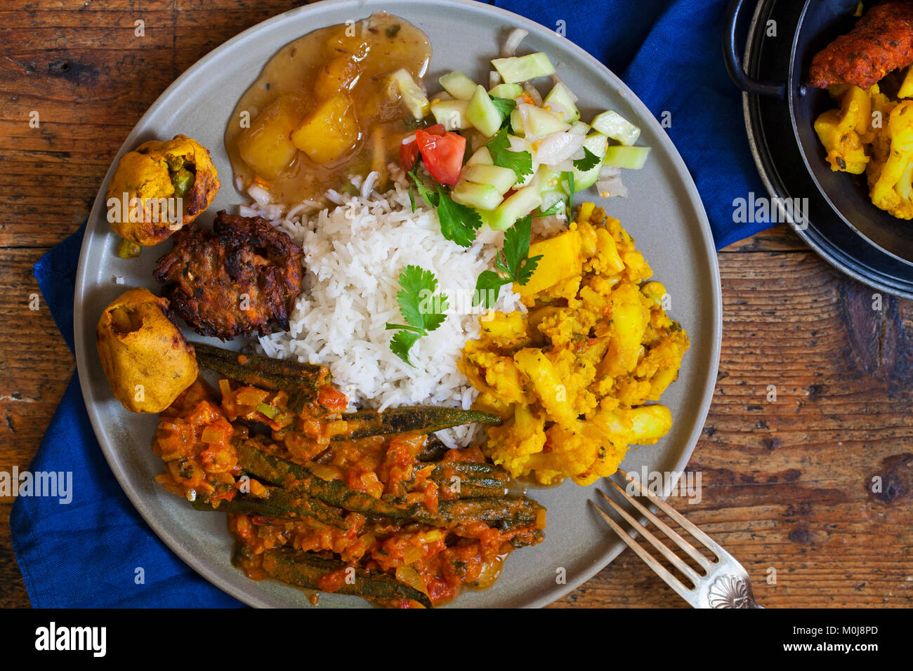 Indian meal with aloo gobi, okra curry, rice and pakoras Stock Photo