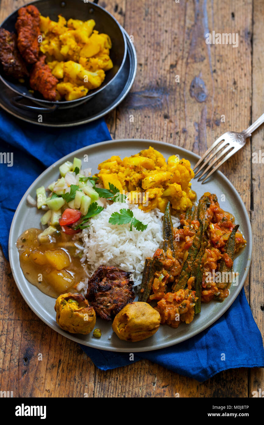Indian meal with aloo gobi, okra curry, rice and pakoras Stock Photo