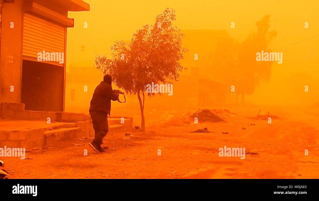 Still image taken from a propaganda video released January 19, 2018 showing Islamic State fighters launching an attack against Syrian government forces during a sandstorm in Al-Bahrah near Deir ez-Zor, Syria. Stock Photo