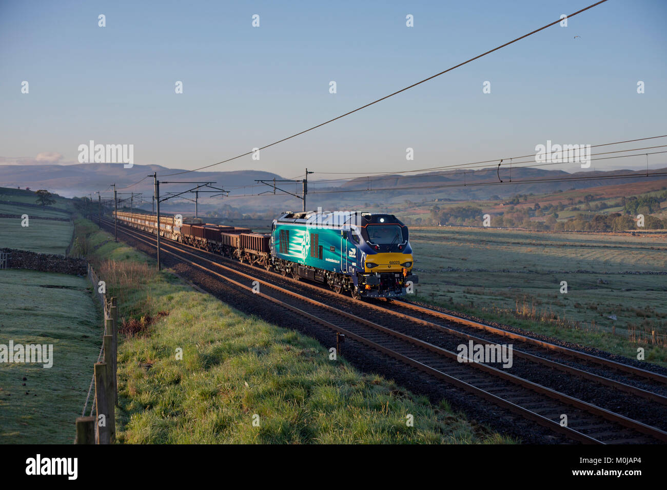 A Direct rail Services class 68 locomotive passes Salterwath (south of Shap Summit, Cumbria)with a Crewe - Carlisle network rail freight train Stock Photo