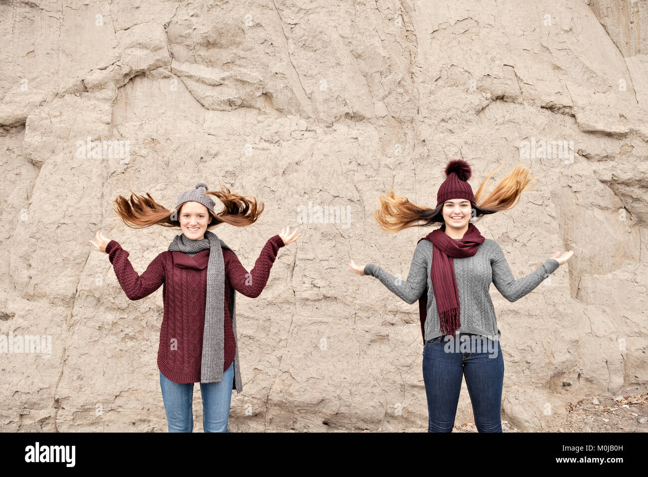 Two friends standing in front of the Scarborough Bluffs and flipping hair up; Scarborough, Ontario, Canada Stock Photo